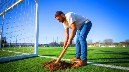 L'employé municipal face à un défi titanesque : creuser le terrain pour relever une barre transversale trop basse sur ce terrain de football