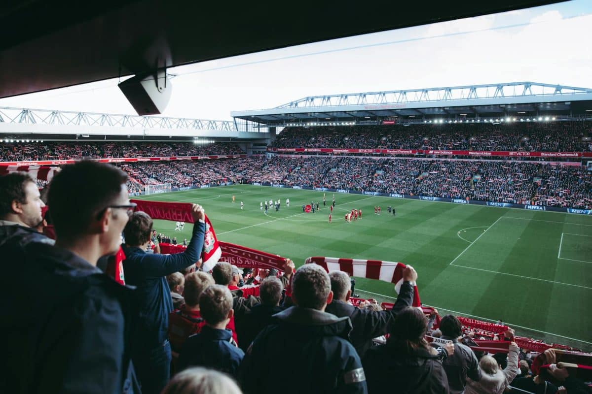 Guide complet pour comprendre et débuter les paris sportifs en Belgique Fans cheer as players take the field at a vibrant football stadium, creating an electric atmosphere.