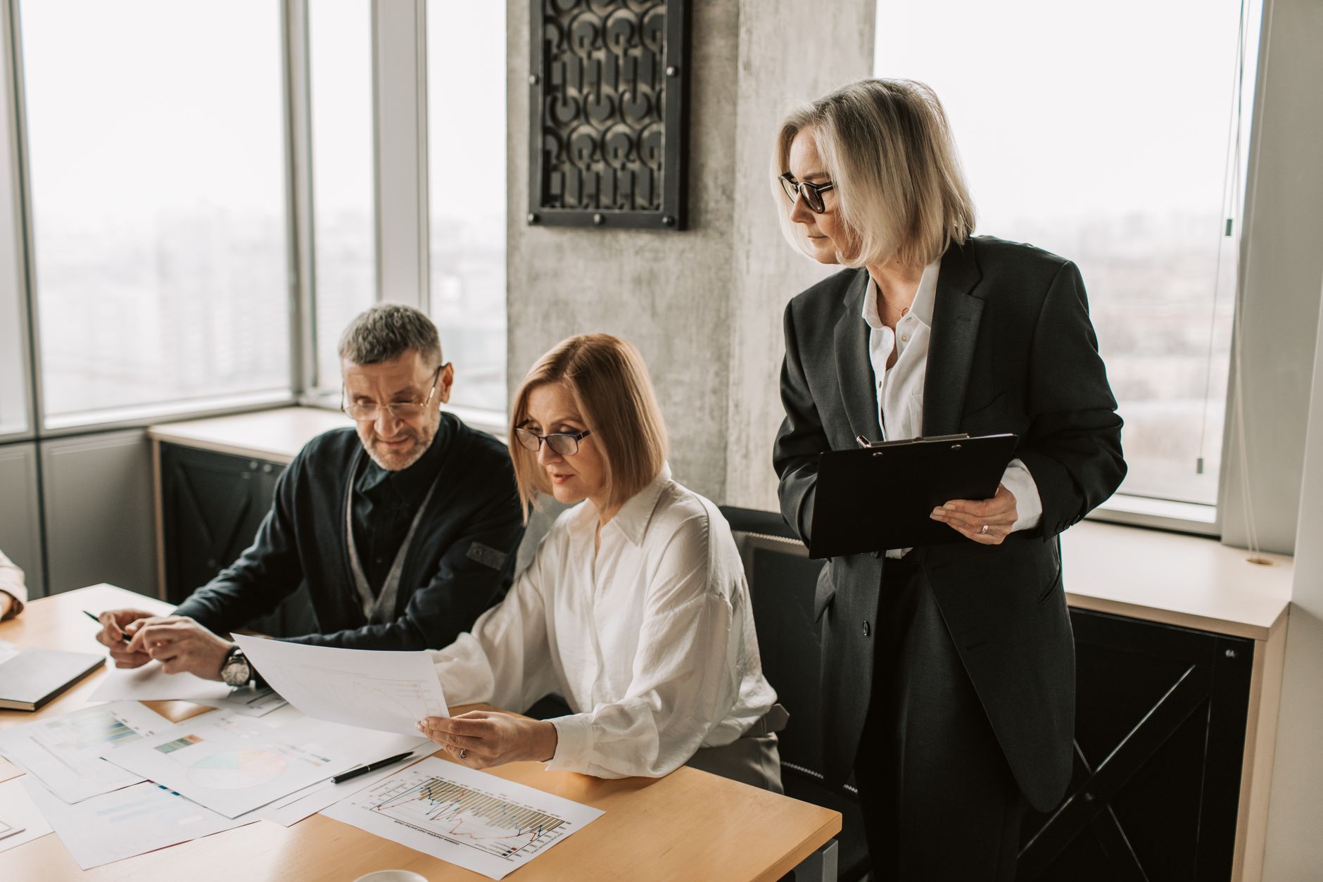 Des collaborateurs réunis autour d’une table examinent attentivement des documents de travail.