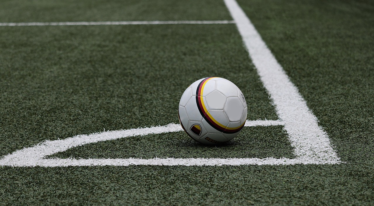 Un ballon de football posé près du point de corner sur un terrain
